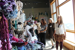 three people view the crocheted coral reef exhibit at Long Marine Lab
